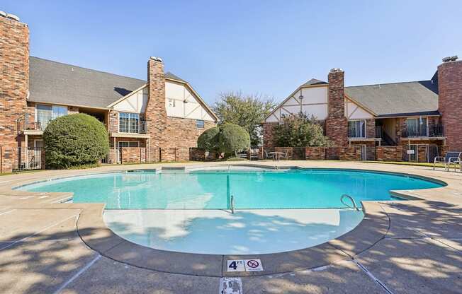 A swimming pool surrounded by a brick building.