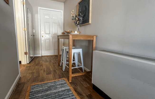a living room with a table and a hallway with a door