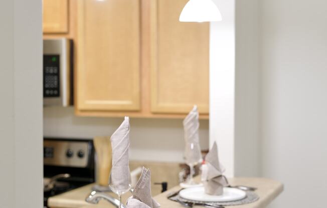 a kitchen with a sink and a counter top with plates and napkins on it