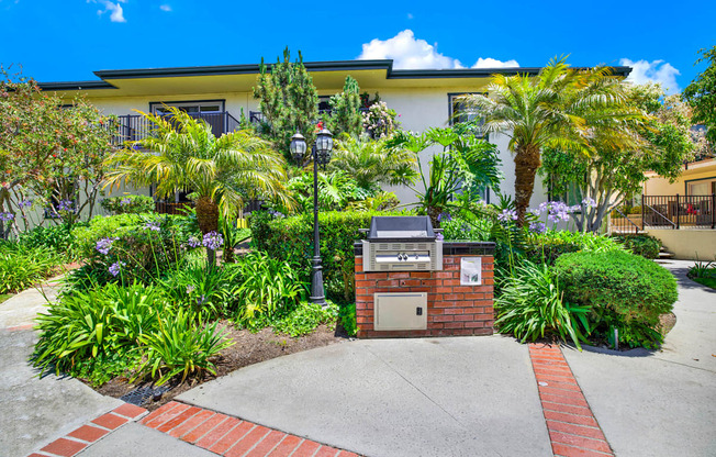 a building with a driveway and palm trees in front of it at Camino de Oro Apartments, California, 90505