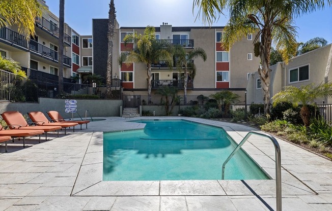 a swimming pool with an apartment building in the background