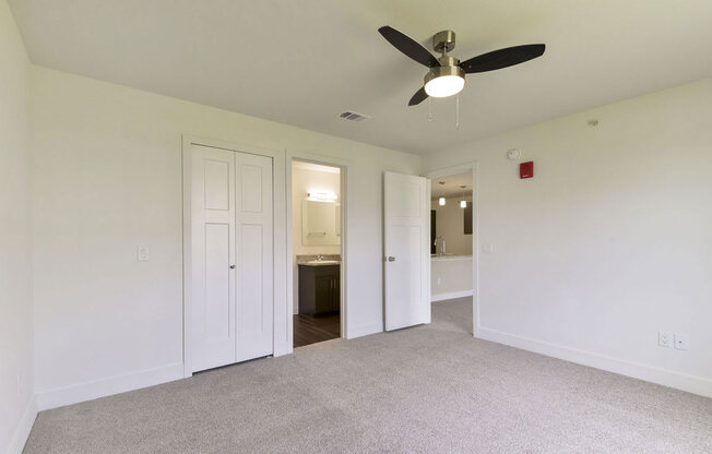 an empty bedroom with a ceiling fan and ensuite at Copper Creek Apartment Homes, Kansas, 67101