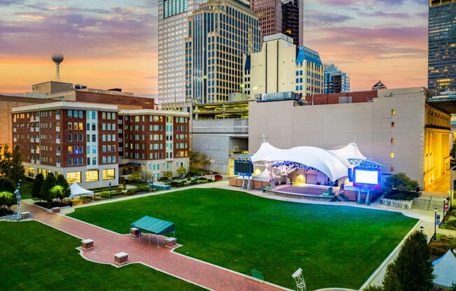 a view of a park and the city skyline at sunset