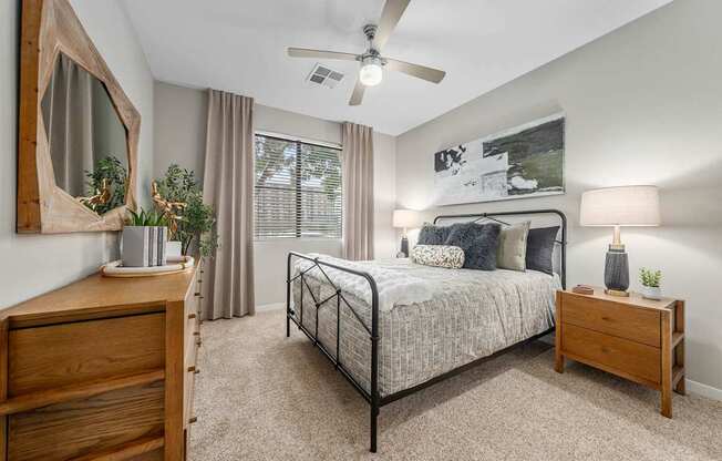 A bedroom with a bed, nightstand, and a dresser.