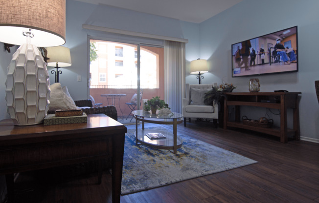 A living room with a sofa, a coffee table, a lamp, and a television.