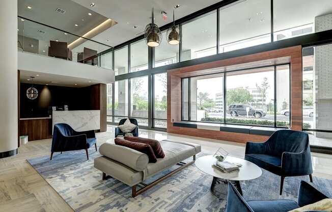 a living room with a couch and chairs and a large window