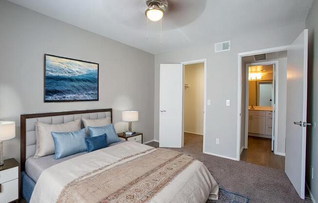 A bedroom with a large bed and a painting on the wall.