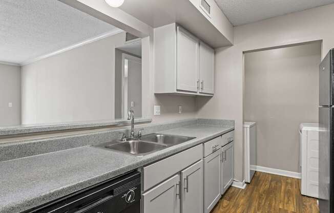 A kitchen with a black oven and wooden floors.