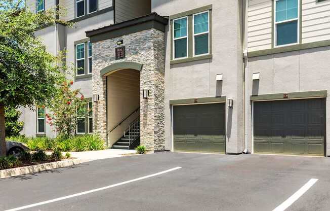 A modern two-story house with a stone archway entrance and two garage doors.