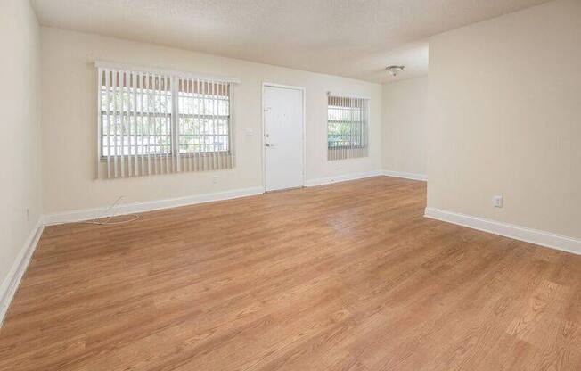 an empty living room with a wooden floor