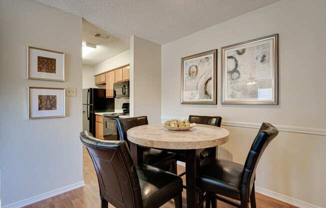 a dining area with a table and chairs and a kitchen