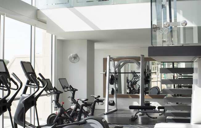 a room with a lot of exercise equipment and a chandelier