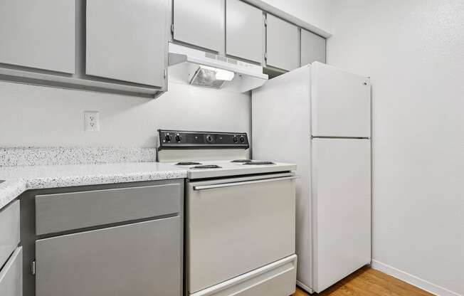 A kitchen with a white refrigerator and a stove top oven.