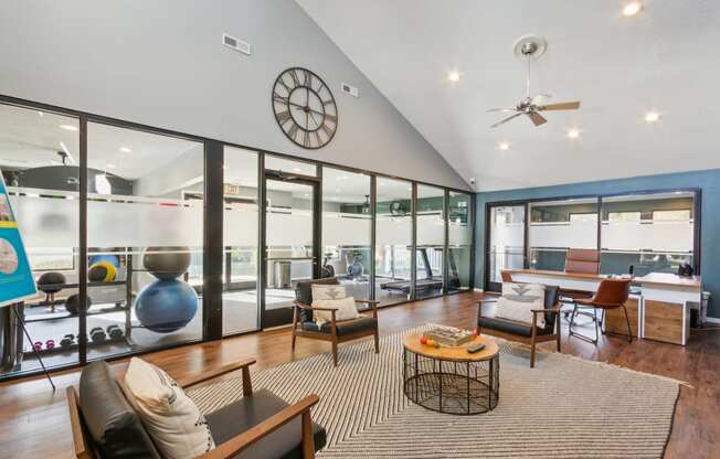 a living room with glass walls and a clock on the ceiling