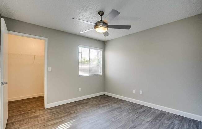 A room with a ceiling fan and a door leading to another room at Sterling Point Apartment Homes, Arizona