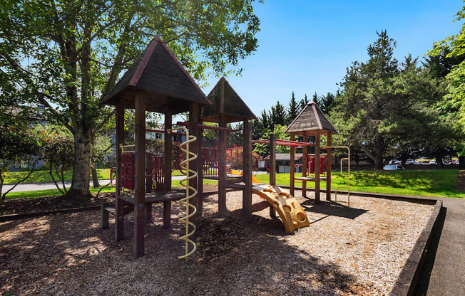 a playground with a swing set and other play equipment at Eagles Landing Apartments, Everett, 98204