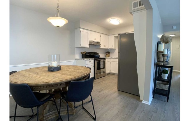 A kitchen with a table and chairs.