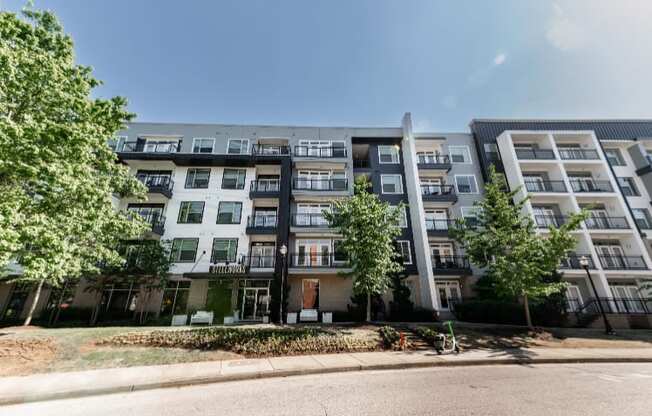 an apartment building on a street with trees in front of it