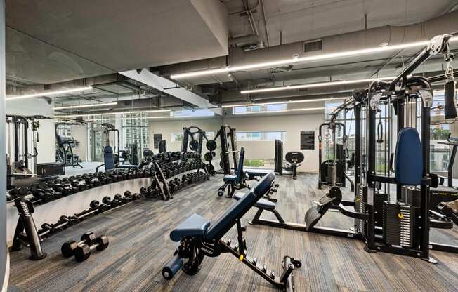 a spacious fitness center with cardio equipment and weights