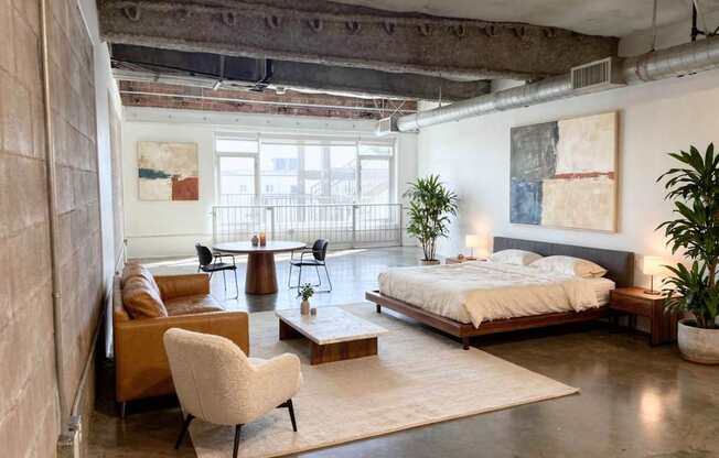 A bedroom with a bed, chair, and a table.