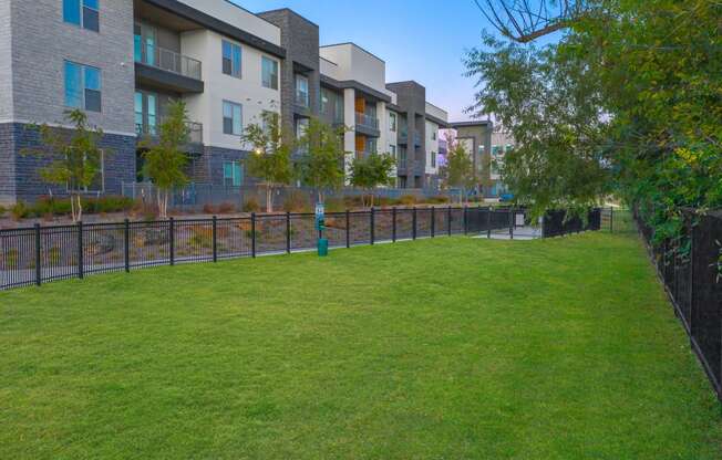 a grassy area with a fire hydrant and apartment buildings in the background at Presidium Revelstoke, Fort Worth, 76131