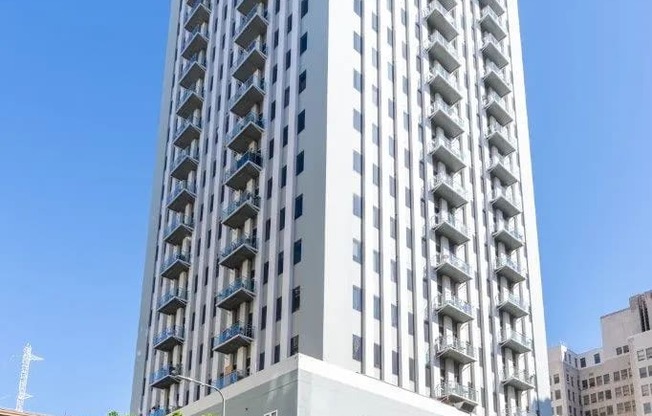 a tall building on a city street with a blue sky
