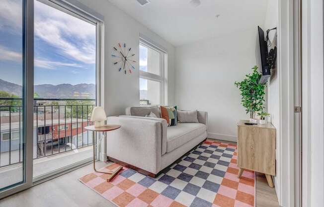 A living room with a couch, a table, a plant, and a TV.