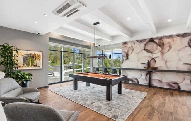 A room with a pool table and a large painting on the wall.