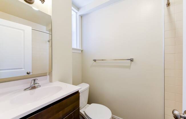 bathroom with sink, toilet, tub and large mirror at petworth station apartments in washington dc