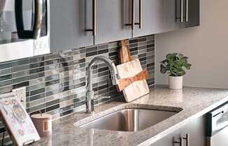 A modern kitchen with a stainless steel oven and a granite countertop.
