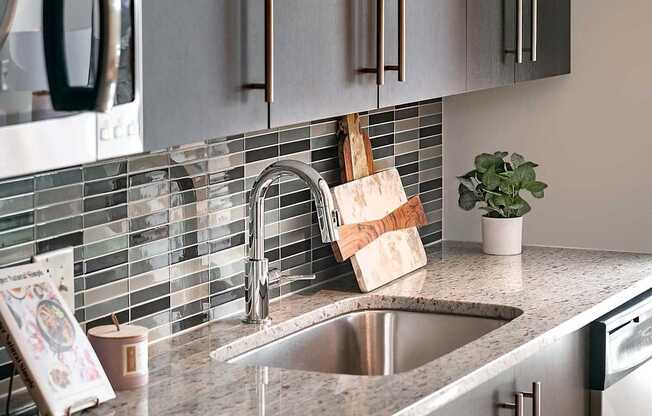 A modern kitchen with a stainless steel oven and a granite countertop.