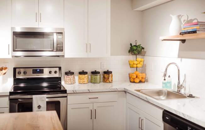 a kitchen with white cabinets and stainless steel appliances