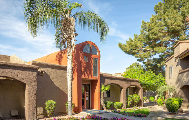 Building exterior with palm trees and lush grass at Glen Oaks Apartments, Glendale, AZ