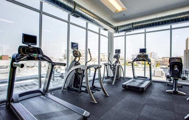 a gym with floor to ceiling windows and cardio equipment