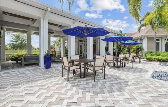 a patio with tables and chairs and umbrellas