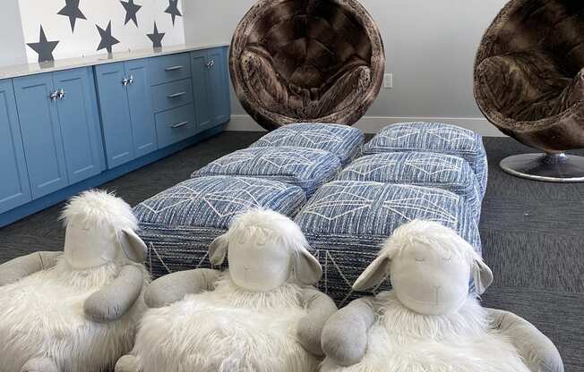 Four stuffed sheep are sitting on the floor at Portofino Vineyards Apartment, Florida