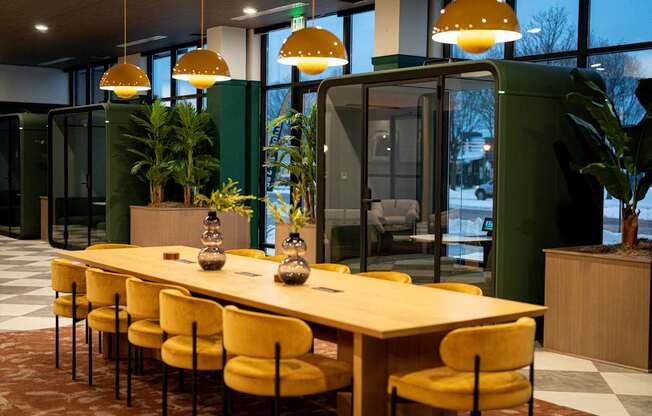 A conference room with a long table and yellow chairs.