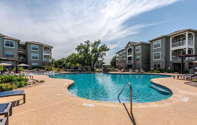 A pool with builings in the background.