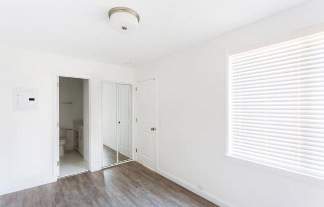 an empty room with a large window and white walls