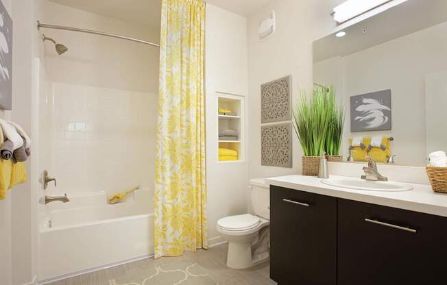 A bathroom with a white tub and yellow shower curtain.