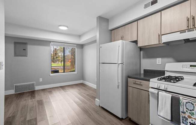 A kitchen with a white fridge and stove top oven.