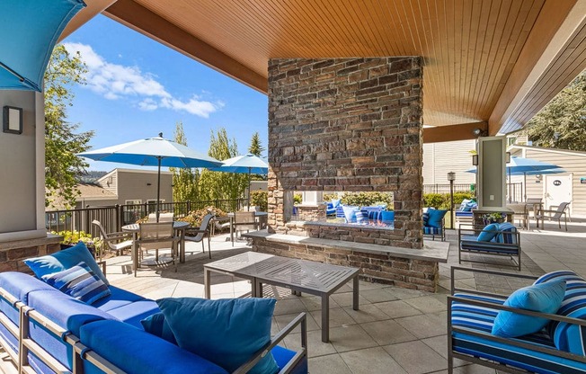 the outdoor patio has a fireplace and tables with umbrellas