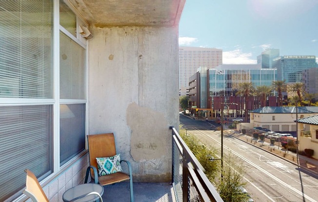 a balcony with a chair and a view of the city