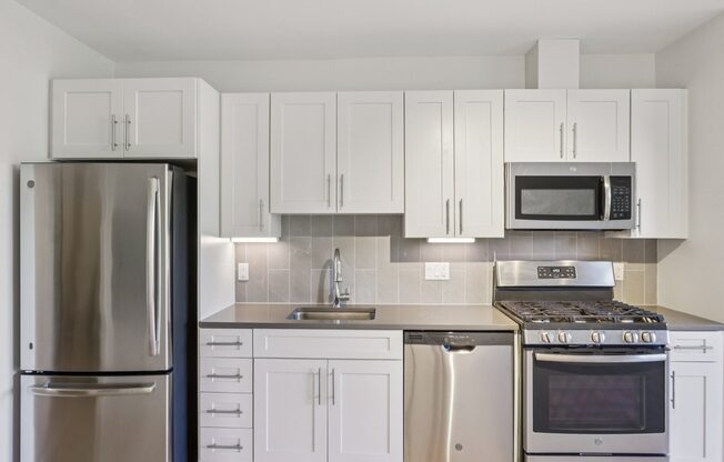 Beautiful kitchen with white cabinets and refrigerator at Park77 Apartments, Massachusetts