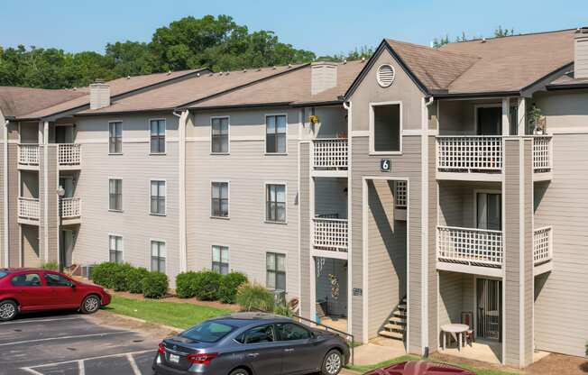 an apartment building with cars parked in a parking lot