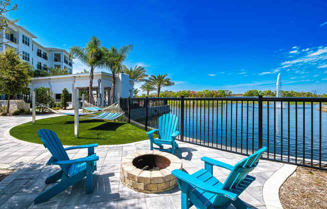 a patio with chairs and a fire pit overlooking a body of water at Altis Grand Suncoast, Florida, 34638