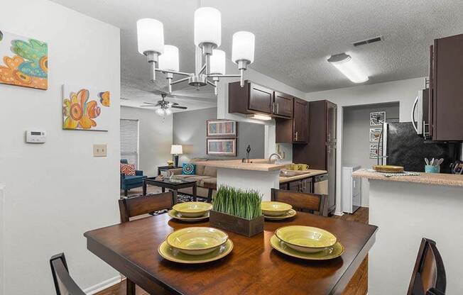 a kitchen and dining room with a table with plates on it