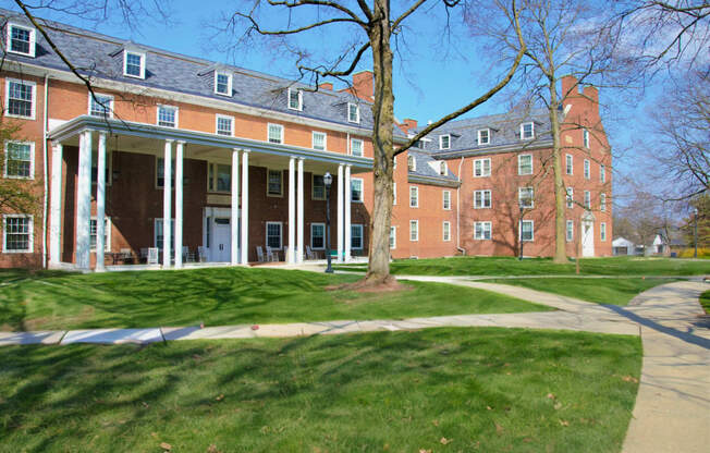 a large brick building with a tree in front of it