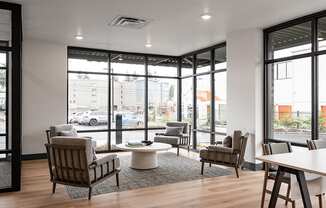 a lounge area with chairs and a coffee table in front of a large window at QUINN BY VINTAGE, Shoreline, WA 98155