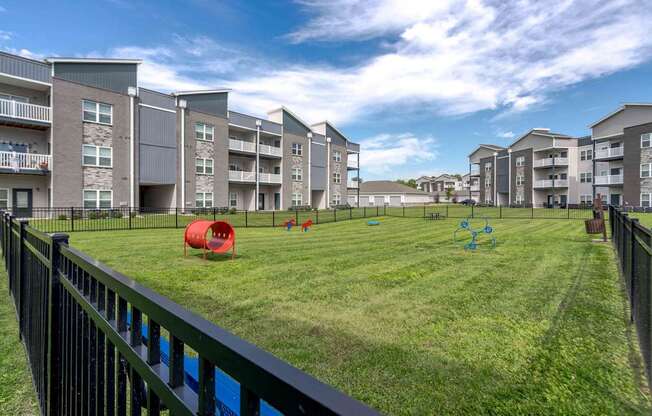 Apartment complex with a green lawn and playground equipment.